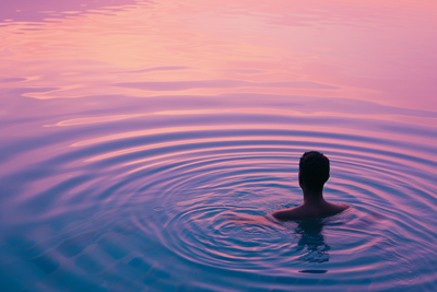 Portrait of a swimmer in tranquil pool at sunrise