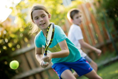 Image of kids playing tennis in backyard