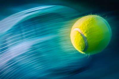 Photo of tennis ball on colored background